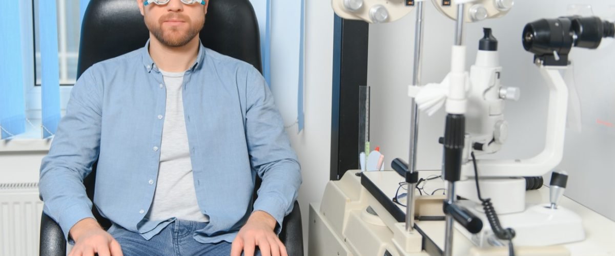 Handsome young man is checking the eye vision in modern ophthalmology clinic. Patient in ophthalmology clinic.